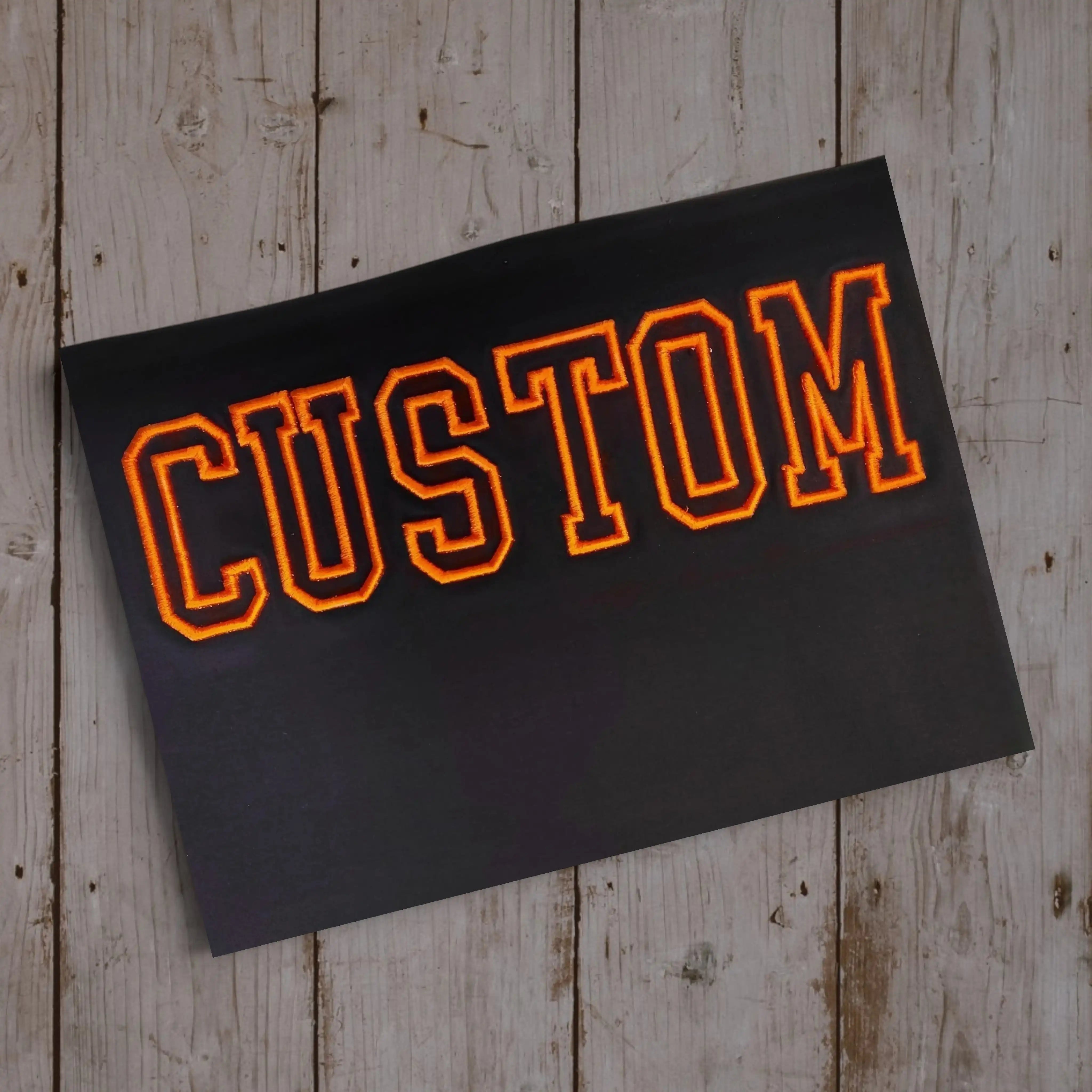 3D outline embroidery CUSTOM in orange on black — machine embroidered by Embroidist