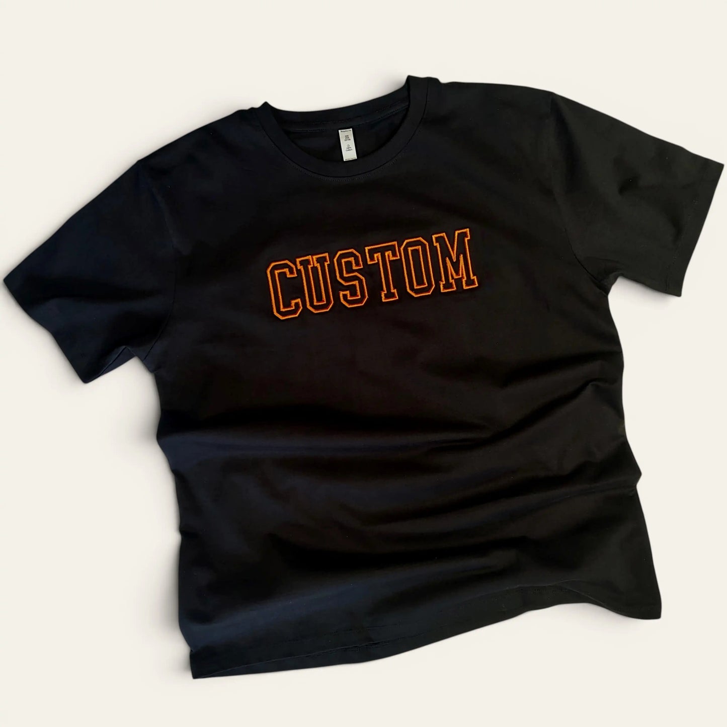 Black custom 3D outline embroidery t-shirt with orange CUSTOM text — made to order by Embroidist