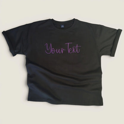 Flat lay of black custom embroidery t-shirt with purple script design