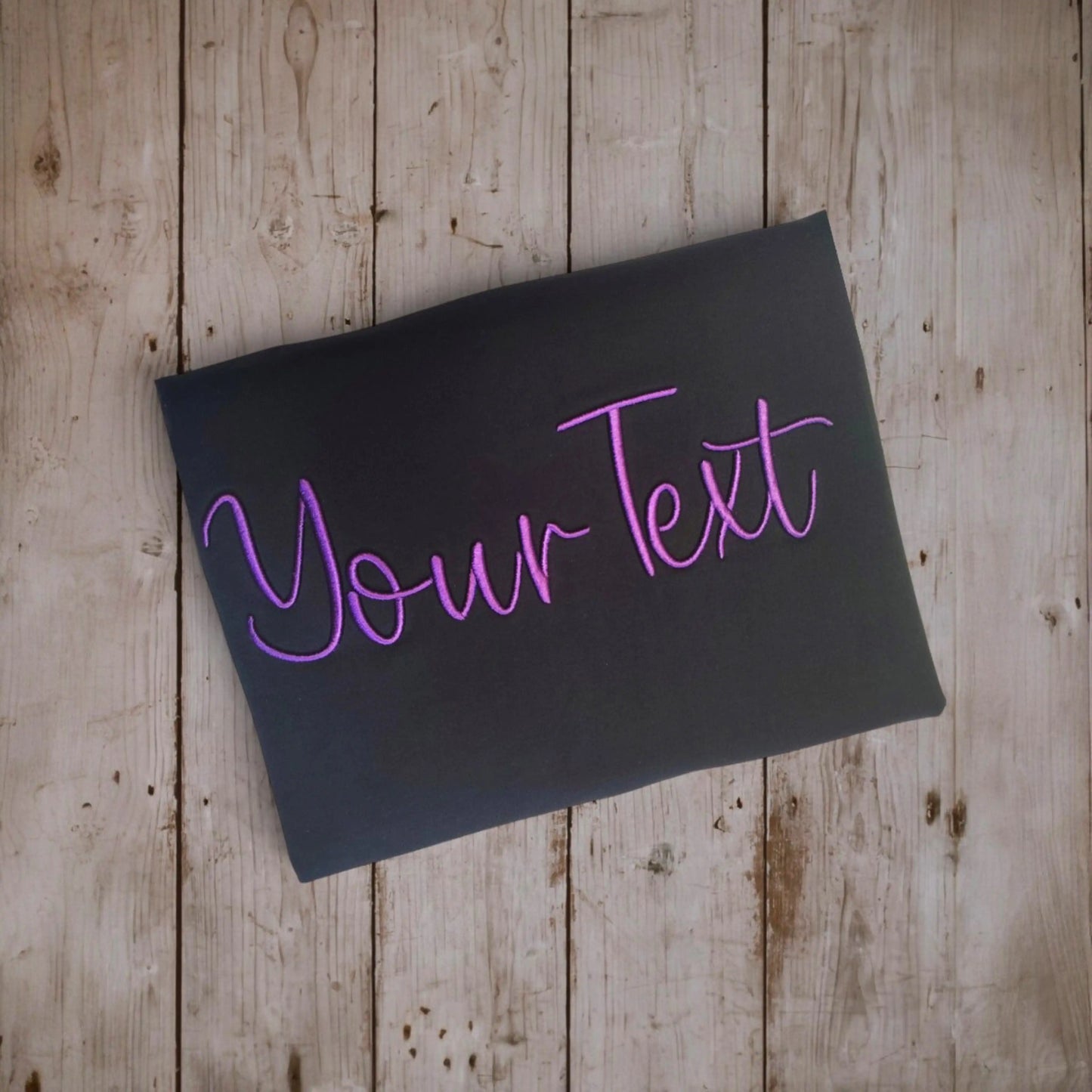 Custom embroidery t-shirt design preview – 'Your Text' in 3D puff purple script on black fabric