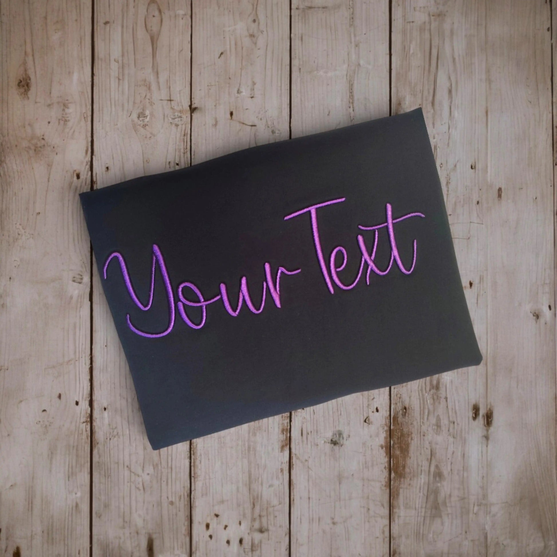 Custom embroidery t-shirt design preview – 'Your Text' in 3D puff purple script on black fabric