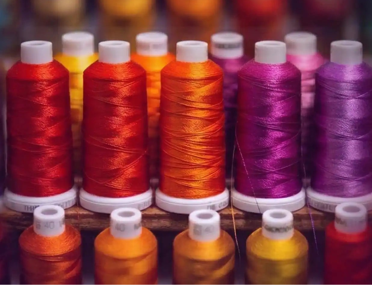 Colorful spools of thread arranged in a row with a blurred background