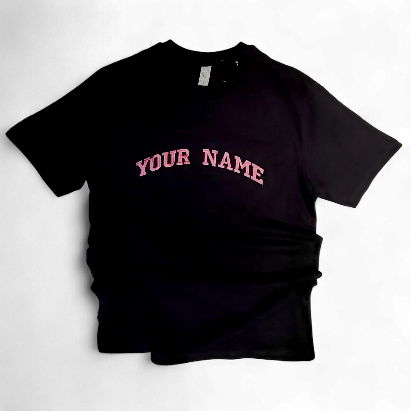 Close-up of pink embroidered letters on black fabric — custom text embroidery by Embroidist