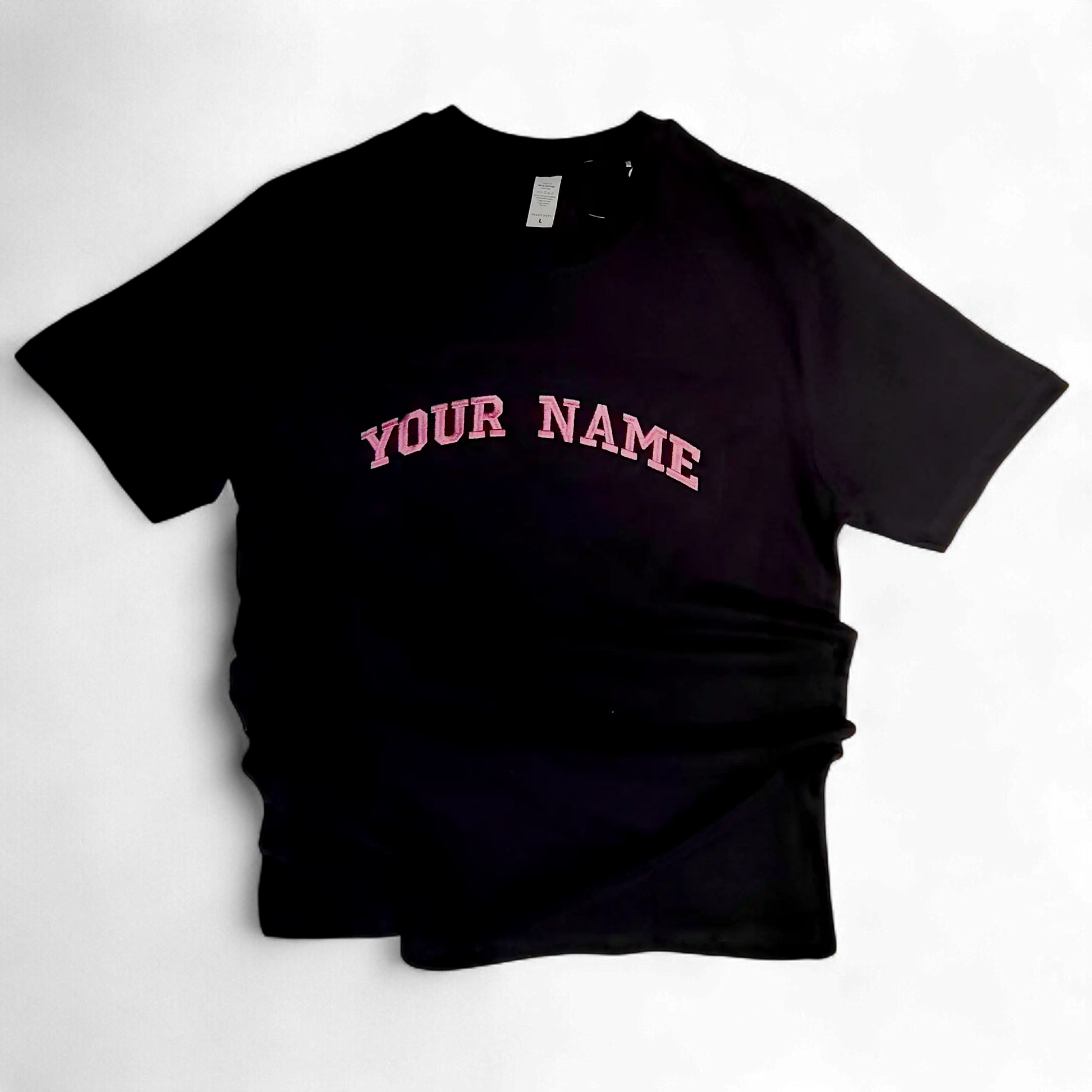 Close-up of pink embroidered letters on black fabric — custom text embroidery by Embroidist