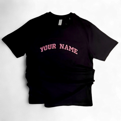 Close-up of pink embroidered letters on black fabric — custom text embroidery by Embroidist