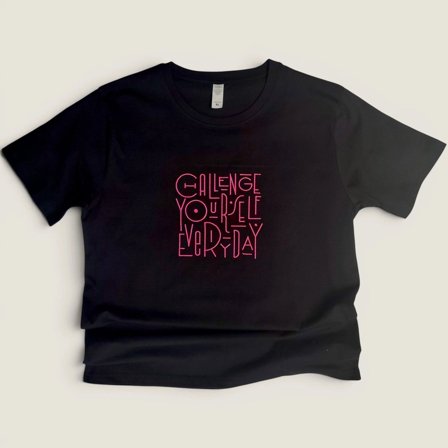 full view of black embroidered t-shirt showing Challenge Yourself Everyday design