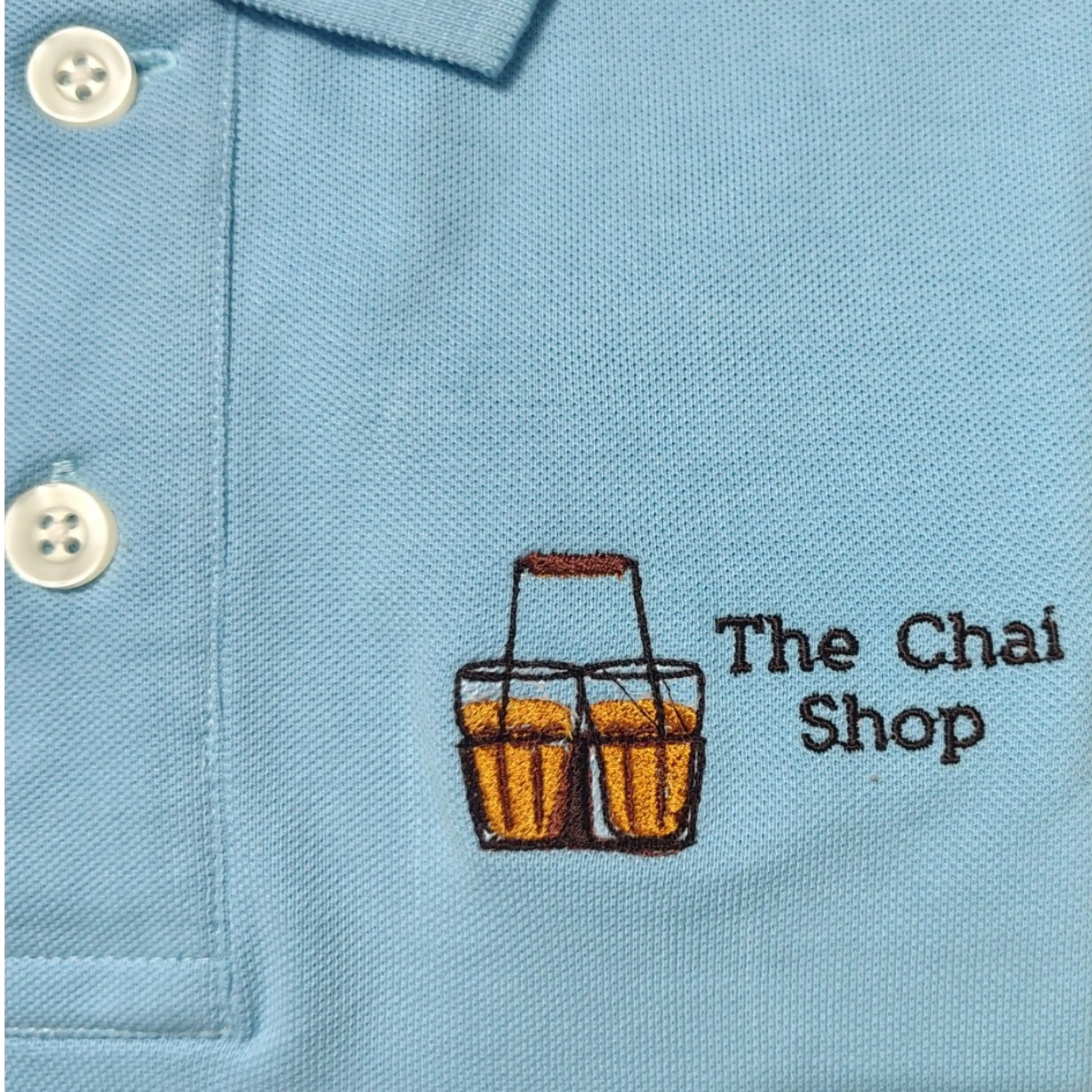 Custom logo embroidery for The Chai Shop on light blue polo t-shirt