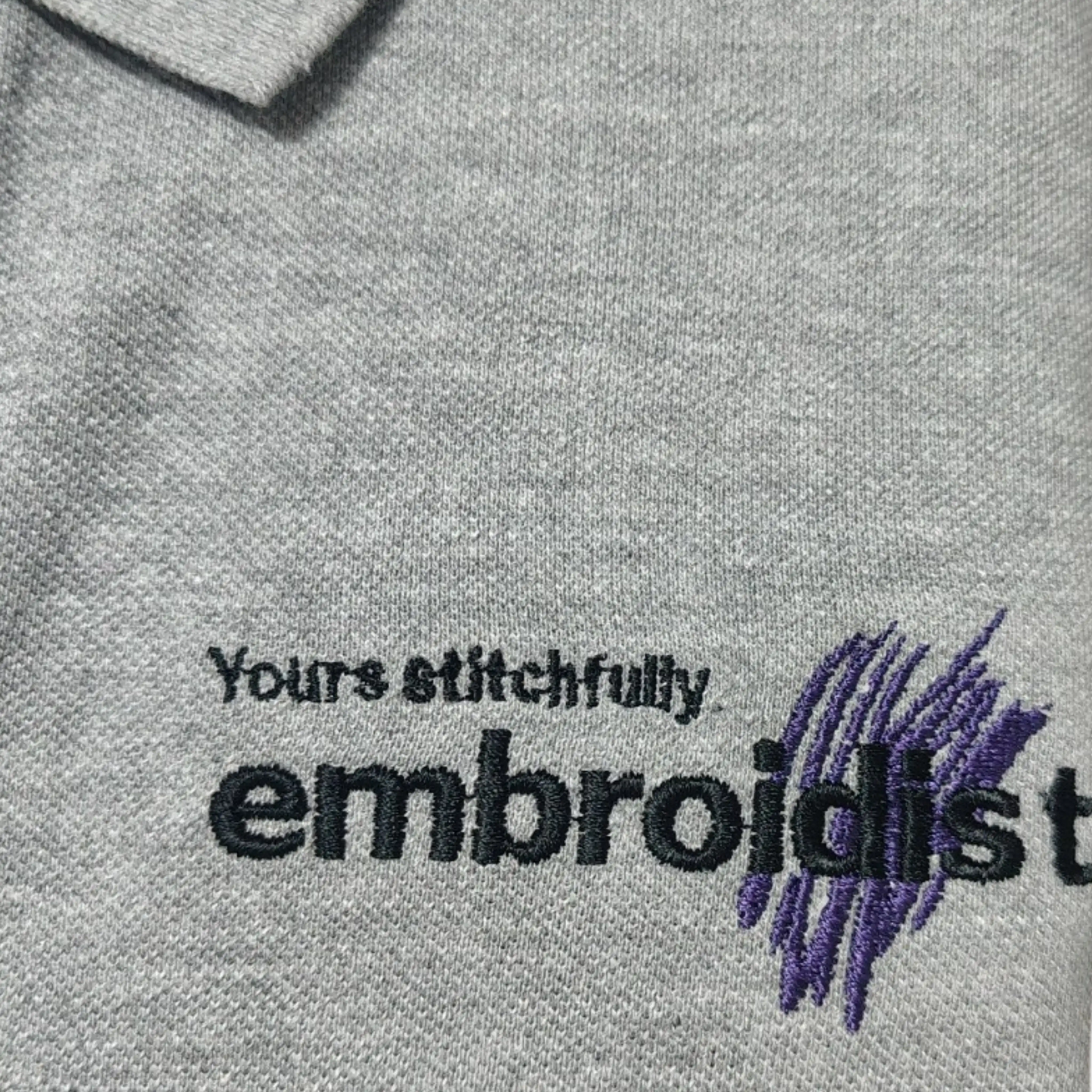 close-up of Embroidist brand embroidery on grey t-shirt