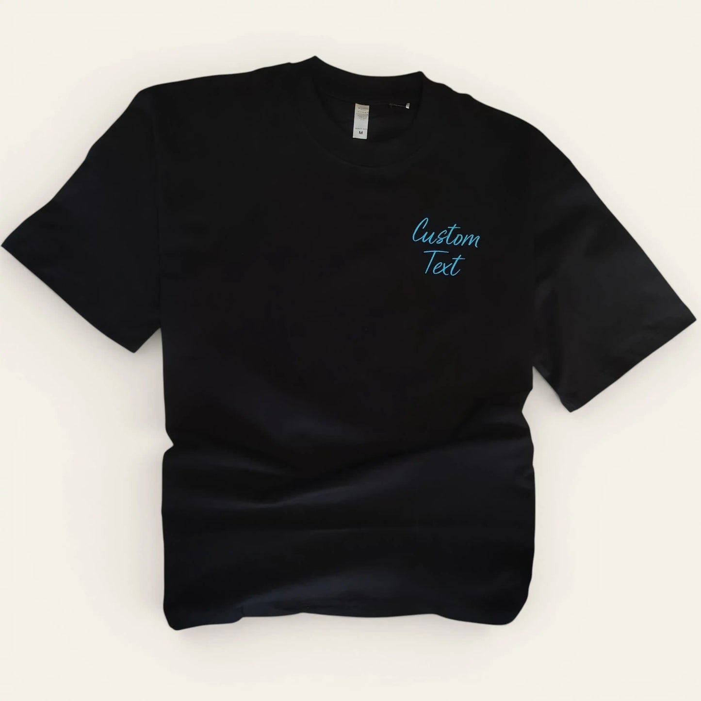 Black oversized t-shirt with left chest custom text embroidery — made to order by Embroidist