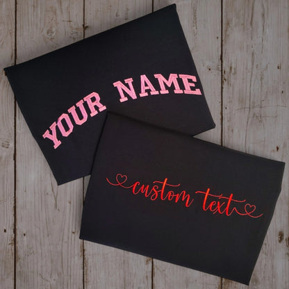 Custom embroidered black t-shirt with pink varsity YOUR NAME and cursive custom text — Embroidist