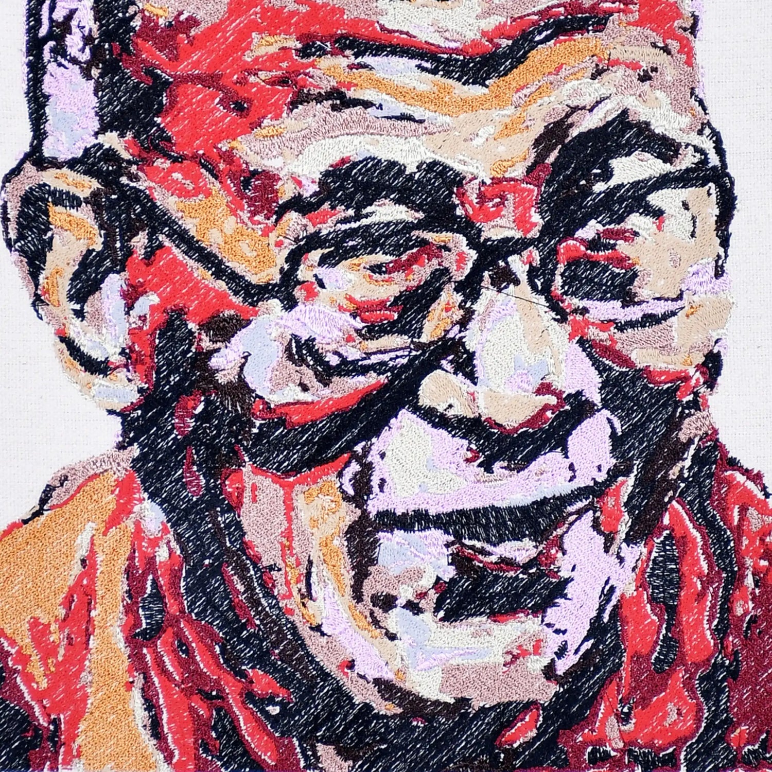 Close up of Dalai Lama thread embroidery portrait detail — spiritual wall art by Embroidist