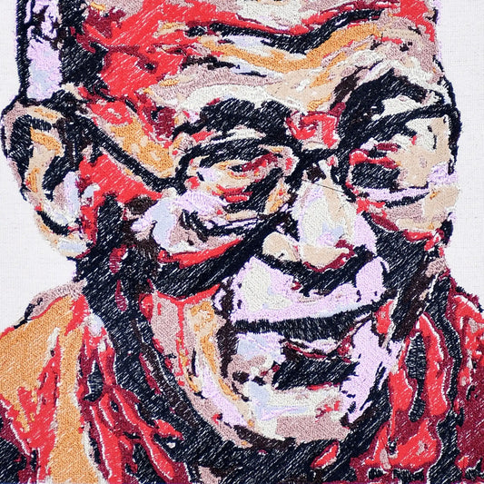 Close up of Dalai Lama thread embroidery portrait detail — spiritual wall art by Embroidist
