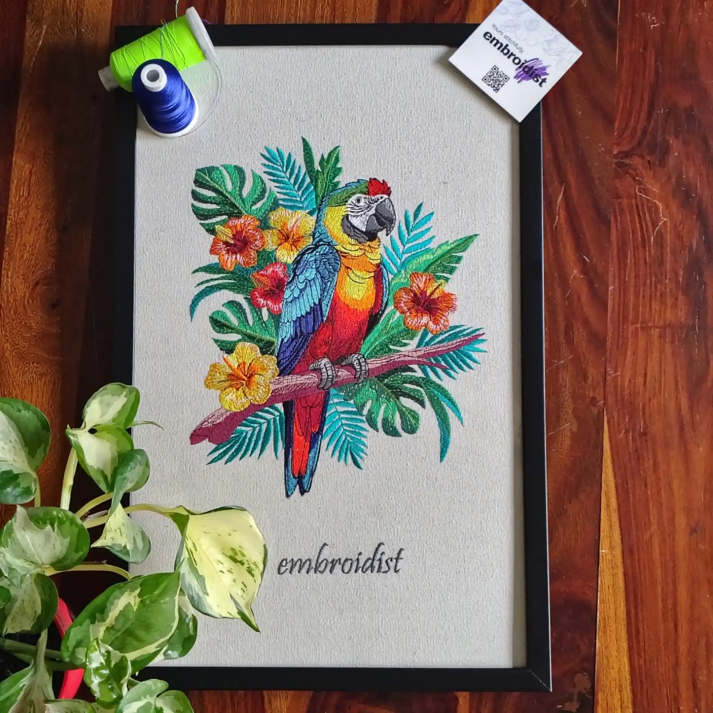 Macaw embroidered wall art lifestyle image — framed art in home setting by Embroidist