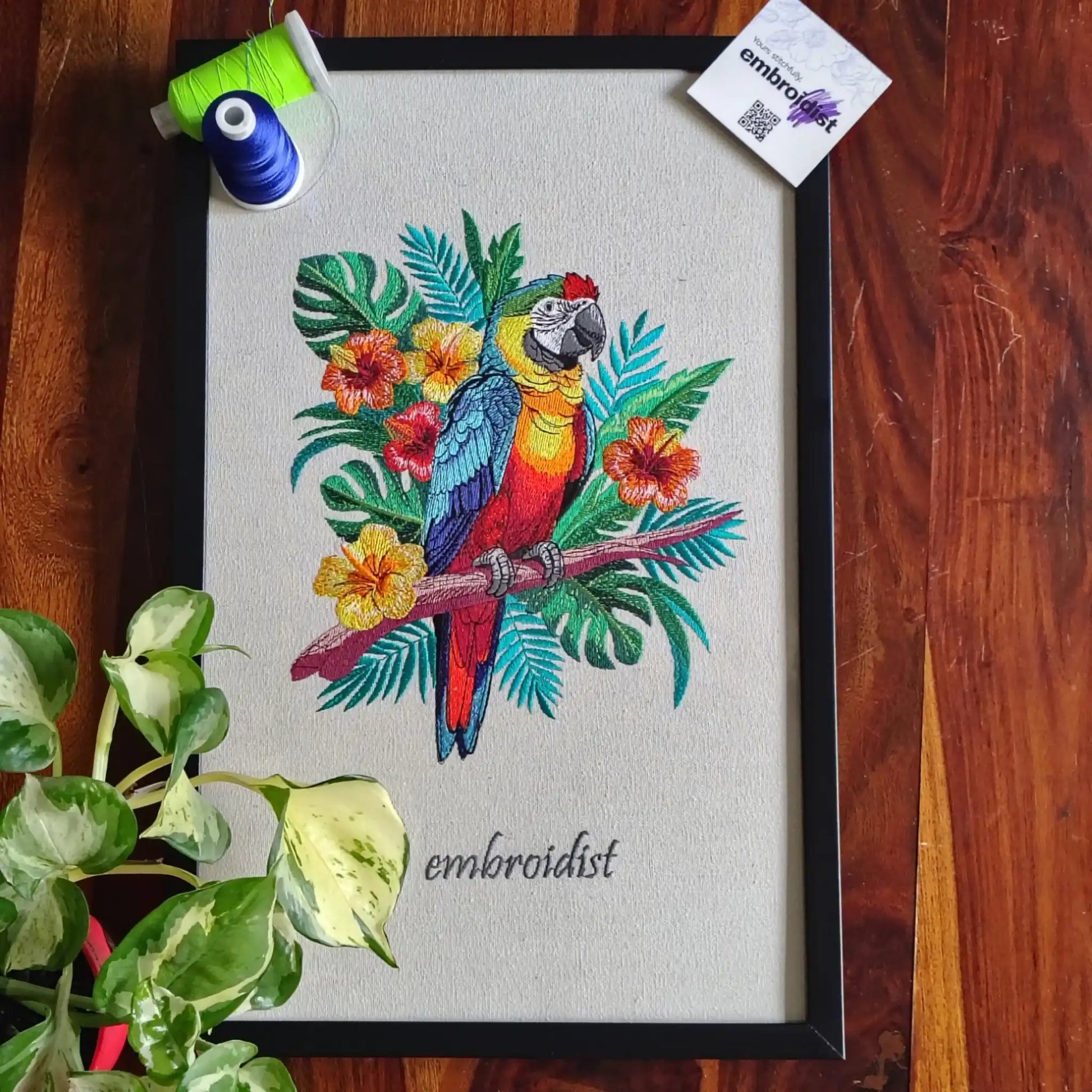 Macaw embroidered wall art lifestyle image — framed art in home setting by Embroidist