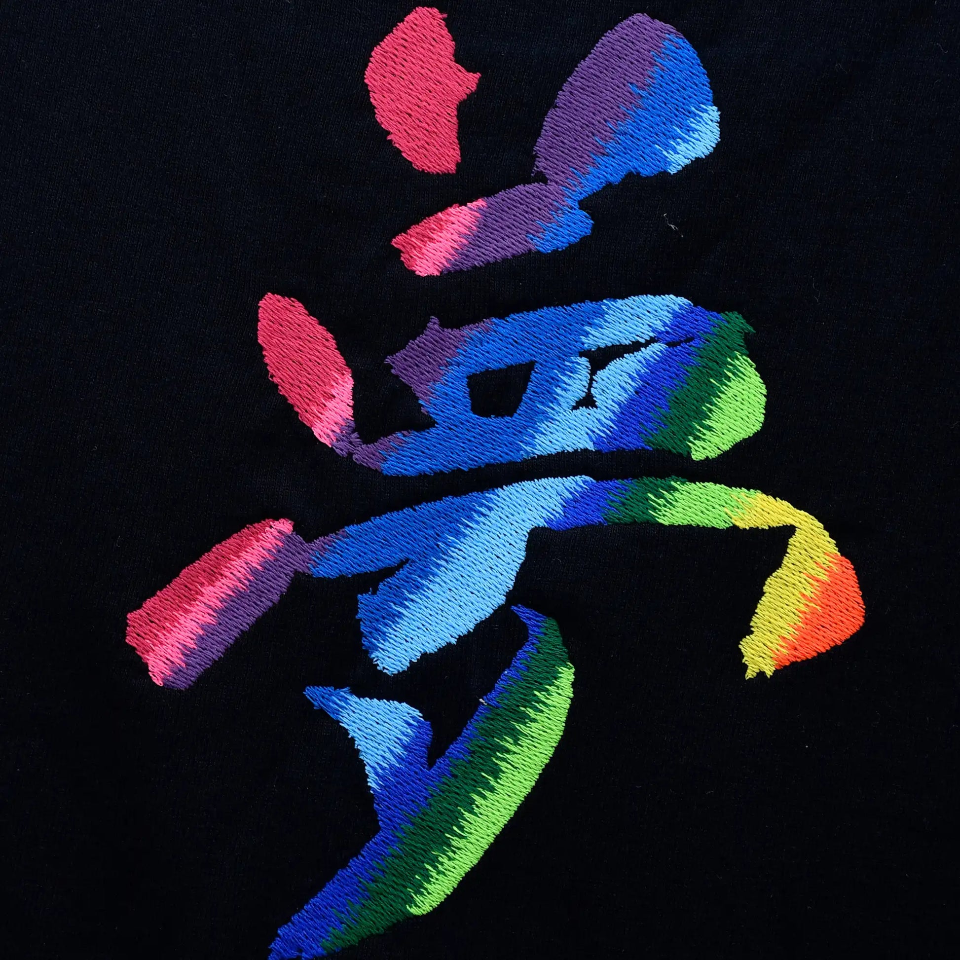 Close-up of 夢 Japanese kanji for "Dream" embroidered in 10-colour rainbow satin stitch on black fabric — 16,016 stitches, by Embroidist.