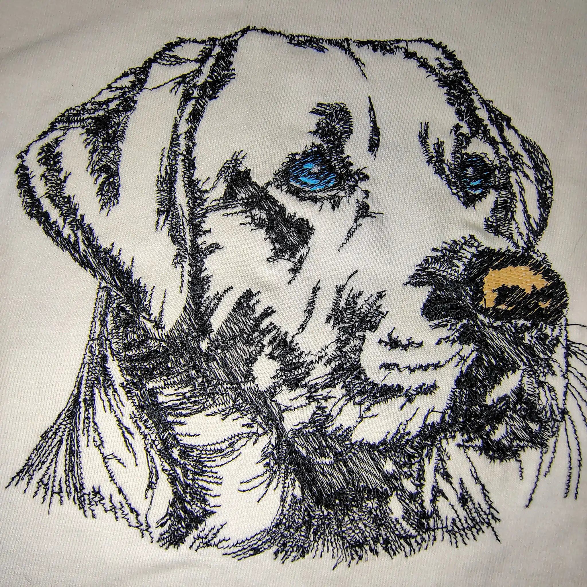 Close-up of Labrador dog face machine embroidery on white t-shirt — custom pet portrait by Embroidist