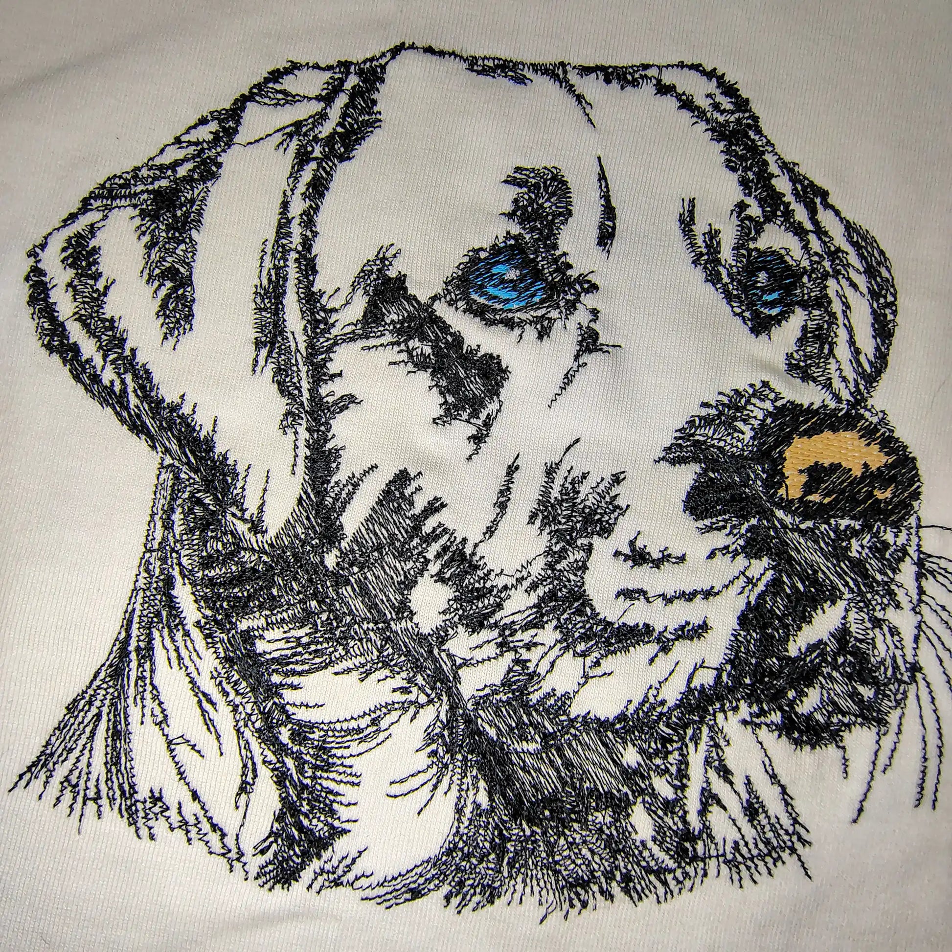Close-up of Labrador dog face machine embroidery on white t-shirt — custom pet portrait by Embroidist