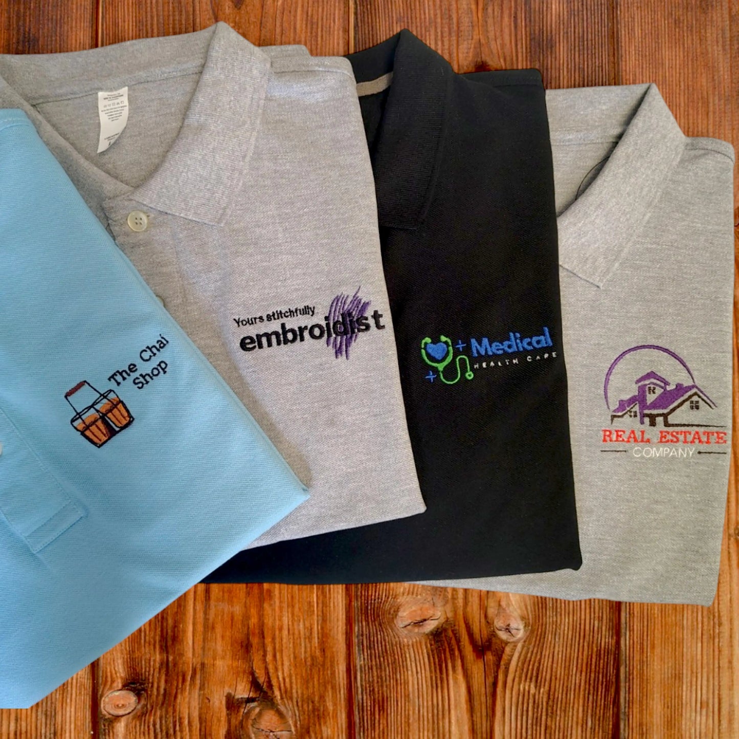 Custom logo embroidery on grey, black and light blue t-shirts by Embroidist