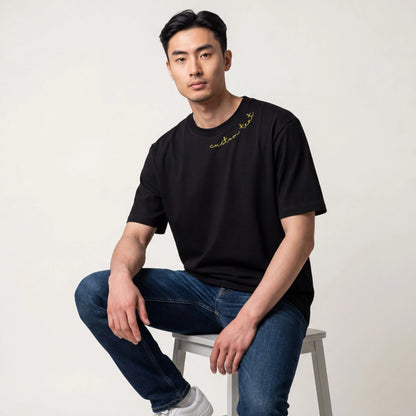 Man wearing black custom name embroidered t-shirt — Embroidist neckline tee
