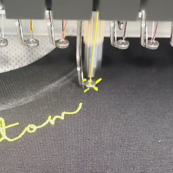 Brother PR-1055X embroidering custom name at tee neckline — in-studio digitized