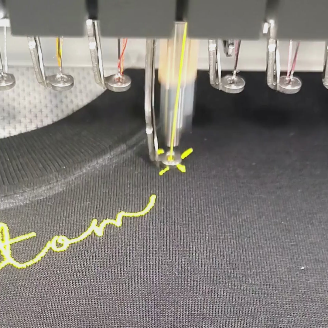Brother PR-1055X embroidering custom name at tee neckline — in-studio digitized