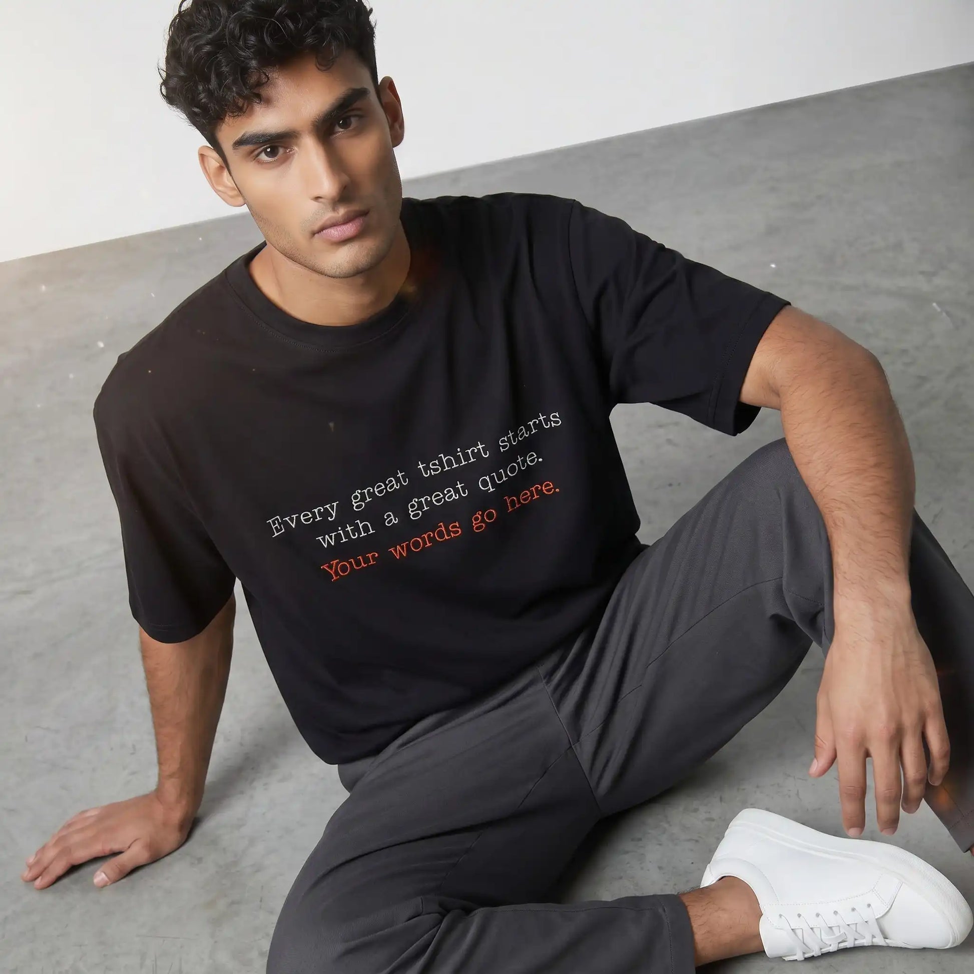 Man wearing custom embroidered black oversized t-shirt with chest text — Embroidist personalised tee