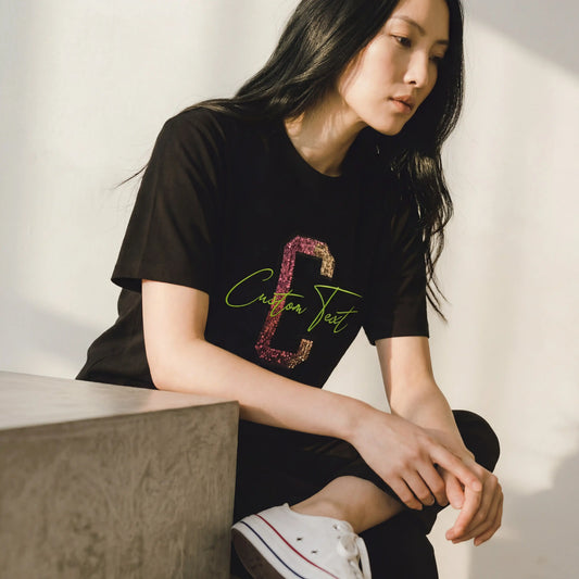 Woman wearing black custom sequin appliqué embroidery t-shirt with pink glitter letter C and lime green script — Embroidist