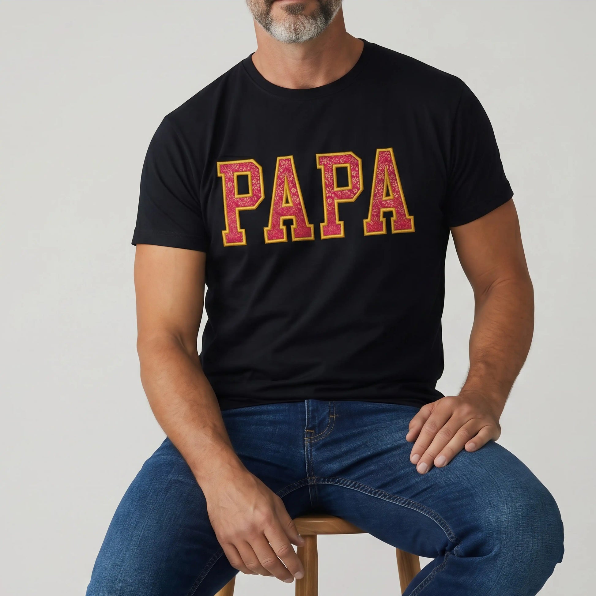 Man wearing custom Zari embroidery t-shirt with PAPA in pink and gold varsity letters | Embroidist